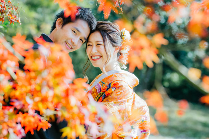 紅葉の前で笑顔のお二人